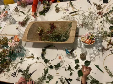 Blumen werden auf einem Tisch für eine DIY-Dekoration arrangiert.