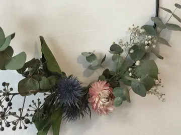 Dekorative Blumen und Blätter hängen an einer Wand.