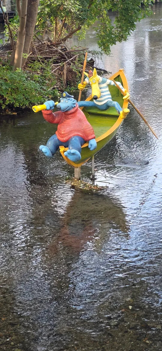 Tierstatuen rudern in einem Bach.