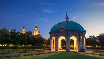 Pavilion illuminated at night in a park.