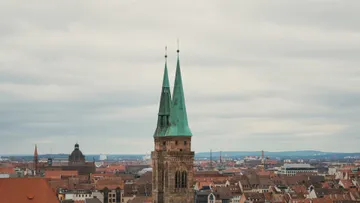 Kirchturm mit Kupfertürmen überblickt Stadt.