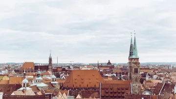 Dächer einer historischen europäischen Stadt unter Wolkenhimmel.