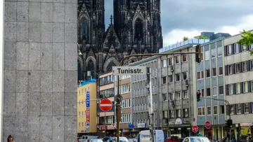 Straße mit Schild, Dom im Hintergrund.
