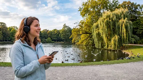 Woman listens to music, park with pond.