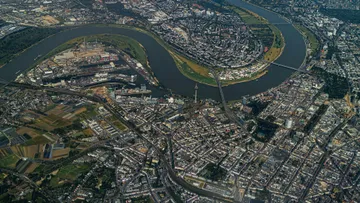 Luftaufnahme einer flussgebogenen Stadt.