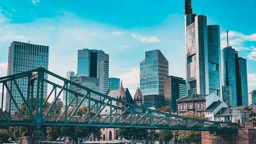 Skyline of skyscrapers behind metal bridge.