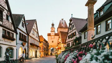 Street with timber houses, tower in background.