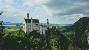 Castle on a hill surrounded by forested landscape.