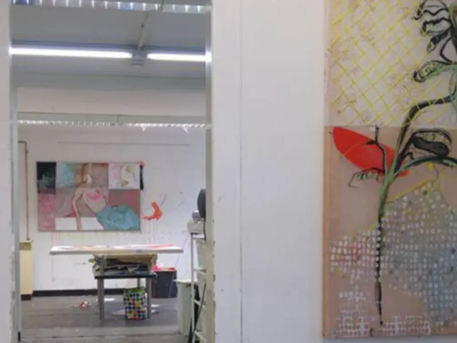 Ein Raum mit Kunstwerken und einem Tisch im Hintergrund.