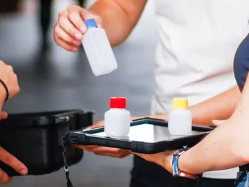 The bottle is held while the tray with more bottles is visible.
