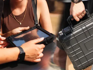Zwei Personen betrachten gemeinsam ein Tablet im Freien.