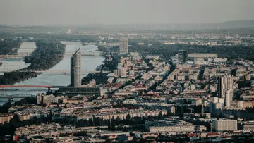 Cityscape with tall buildings by a river.