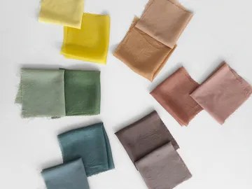 Pieces of fabric in different colors lie on a table.
