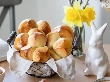 Stacks of baskets with freshly baked rolls decorated with spring flowers.