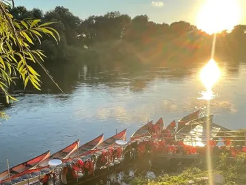 Boats on the shore, sun reflected in the water.