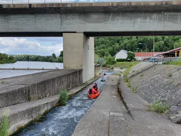 Canoeing in the watercourse under a bridge in nature.