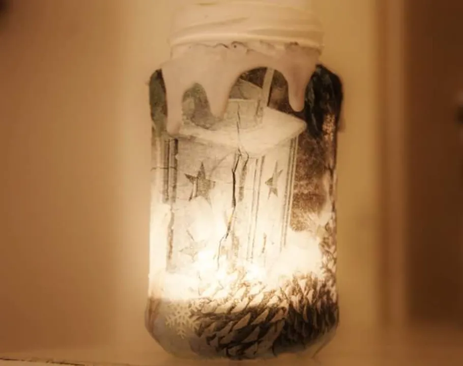 Glas mit Lichtern, Sternendesign, schneebedeckte Deko.