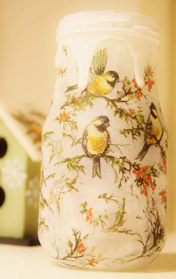 Decorated jar with birds in a cozy setting.
