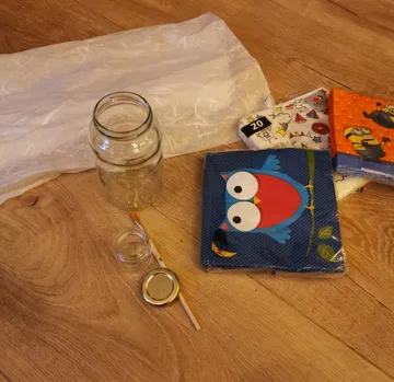 Craft supplies on wooden floor, including napkins.