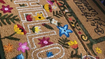 Dekorativer Türvorleger mit Blumen wird bemalt.