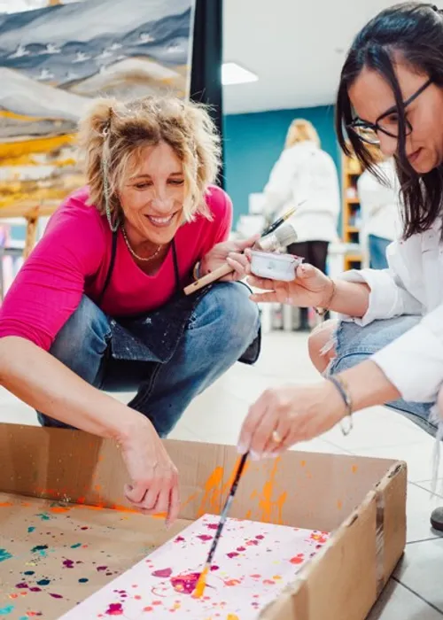 Two women painting in an art studio.