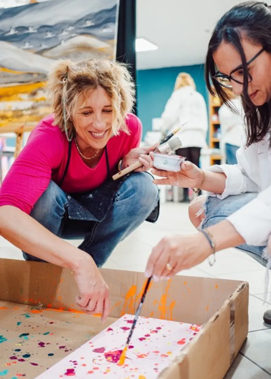 Two women painting in an art studio.