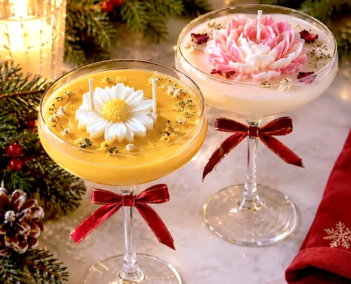 Flower candles in cocktail glasses on table.