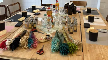 Getrocknete Blumen und Flaschen auf Holztisch.