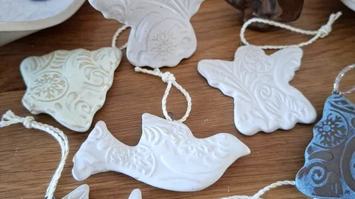 Ceramic ornaments with intricate designs on wood.