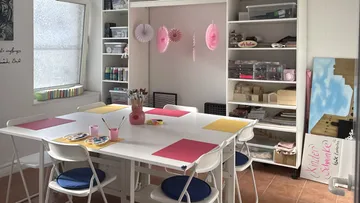 Craft room with table and art supplies.
