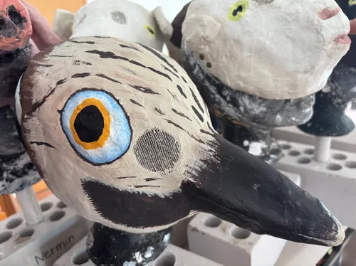 Painted animal masks on display in gallery.
