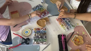 Kids crafting mosaics at a table.