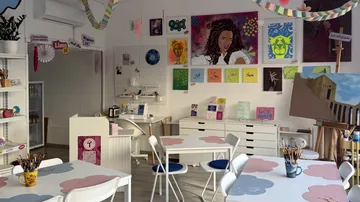 Art studio with colorful paintings displayed.