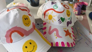Two painted caps with colorful designs on table.