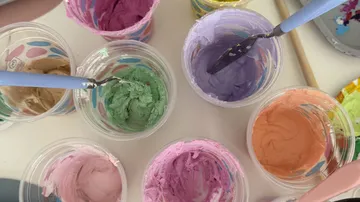 Colorful paint buckets arranged in a circle.