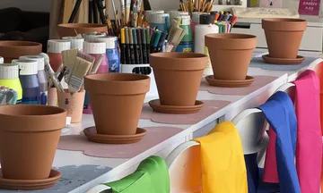 Clay pots on table with art supplies.