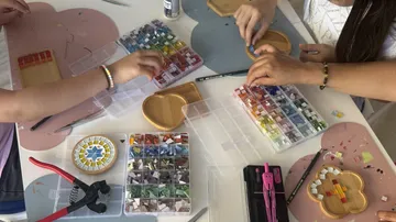 People crafting with colorful mosaic tiles.