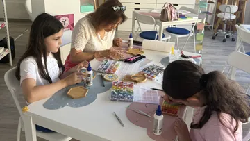Three people crafting at a table.