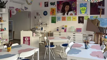 Art studio with colorful paintings displayed.