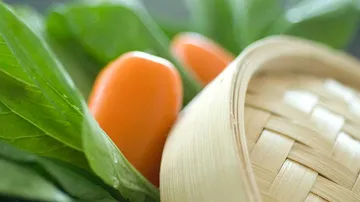 Basket with vegetables, green leaves visible.