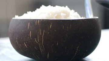 Wooden bowl filled with white rice.