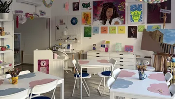 Art studio with paintings displayed on walls.