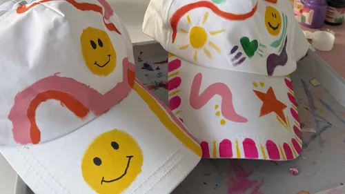 Zwei dekorierte Kappen mit bunten Designs.