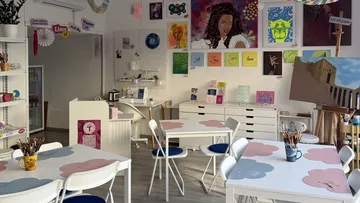 Art studio with colorful paintings displayed.
