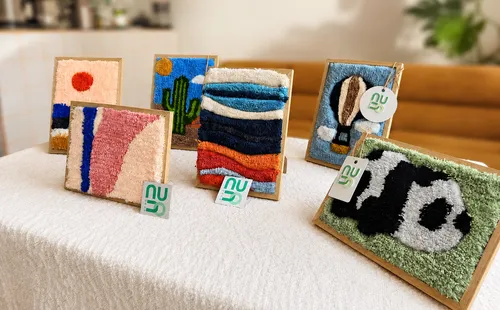 Textile artworks displayed on a table.