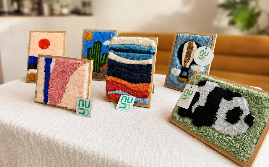 Textile artworks displayed on a table.