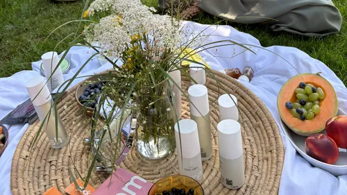Picnic setup with fruits and skincare products.