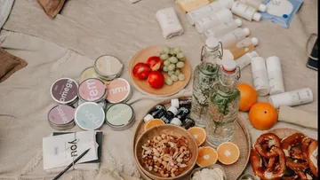 Assorted snacks on a picnic blanket outdoors.