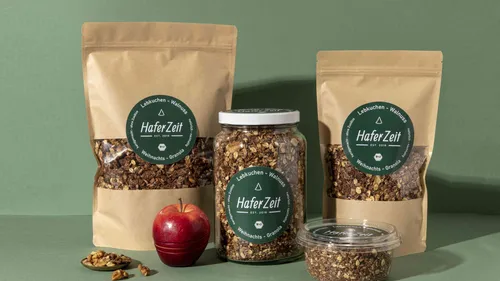 Granola-Verpackung mit Apfel auf grünem Hintergrund.