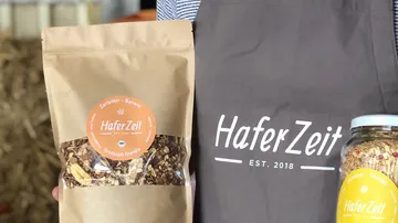 Person holding granola pack and jar.